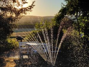 einen Brunnen vor einem Tisch und einer Bank in der Unterkunft Loue joli T2,neuf, de 50m2, dans un cadre paisible in Saint-Gervais-dʼAuvergne