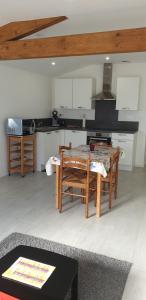 a kitchen with a table and chairs in a room at Loue joli T2,neuf, de 50m2, dans un cadre paisible in Saint-Gervais-dʼAuvergne