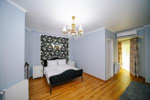 - une chambre avec un lit et un lustre dans l'établissement Rose Hotel & Hostel Vake, à Tbilissi