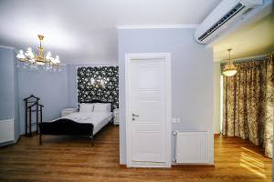 - une chambre avec un lit et un lustre dans l'établissement Rose Hotel & Hostel Vake, à Tbilissi