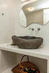 a bathroom with a stone sink and a mirror at Ma mer in Naxos Chora