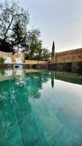 a swimming pool with blue water and a wooden fence at La dolce Giulia in Hyères
