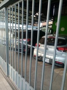 un coche aparcado en un estacionamiento detrás de una valla metálica en Departamentos Camino Real incluye garaje, en Cusco