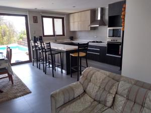 a living room with a couch and a kitchen at Casa Pingueral Tomé in Concepción