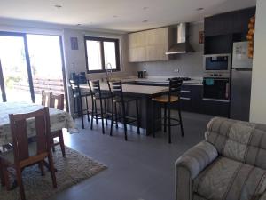 a kitchen and living room with a couch and a table at Casa Pingueral Tomé in Concepción