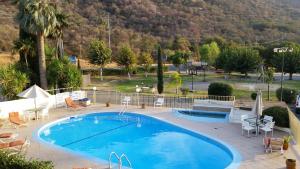 a large swimming pool with chairs and a mountain at Western Holiday Lodge in Three Rivers