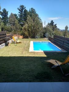 a swimming pool in a yard with a chair next to it at Casa Pingueral Tomé in Concepción