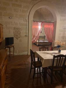 une cuisine avec une table et des chaises ainsi qu'une télévision dans l'établissement Masseria Montanari, à Carpignano Salentino
