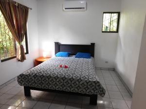 Un dormitorio con una cama con dos zapatos rojos. en Villasjungle 3 en Sámara