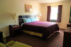 Habitación de hotel con cama y ventana en Quality Quarters Inn, en Richmond