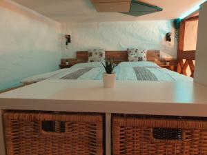 a bedroom with a bed with a table and baskets at Studio Srce in Kranjska Gora