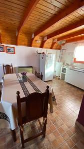 cocina con mesa y nevera en una habitación en Cabañas del Rosario en Puerto Santa Cruz