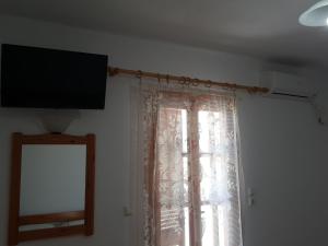 una finestra con una tenda e una televisione su una parete di O Fotis ad Agios Prokopios