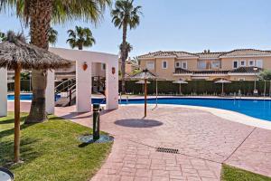un complexe avec une piscine et des palmiers dans l'établissement Cielo Sur Vera Playa, à Vera