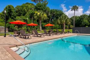 a swimming pool with tables and umbrellas and chairs at Best Western Inn Of Palatka in East Palatka