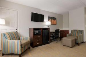 East Palatka的住宿－Best Western Inn Of Palatka，酒店客房配有2把椅子、书桌和电视。