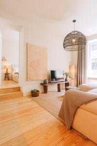 a living room with a bed and a television at Village Aparthotel By BOA in Porto