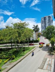 une rue dans une ville avec des voitures et des arbres dans l'établissement Apartaestudio ROMA 402 Edificio Europa Ibagué, à Ibagué