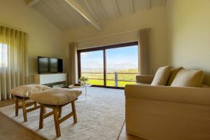 The FarmHouse II - Uma quinta deslumbrante في فيلجويراس: غرفة معيشة مع أريكة ونافذة كبيرة