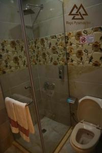 a bathroom with a toilet and a shower stall at Magic Pyramids INN in Cairo