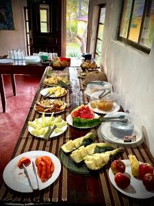 a table with many plates of food on it at Pousada do Sol in Alto Paraíso de Goiás