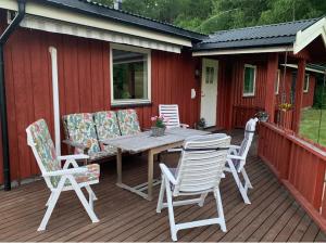 une terrasse en bois avec une table et des chaises. dans l'établissement Feriehus med utsikt til fjord og fjell, 