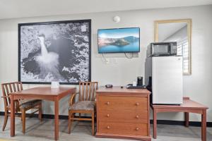 a room with a desk and a refrigerator and a table at Travelers Inn Medford I-5 in Medford