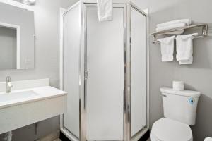 a bathroom with a shower and a toilet and a sink at Travelers Inn Medford in Medford +10 photos