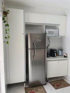 a kitchen with a stainless steel refrigerator and a microwave at Cantinho dos Dalto in Itatiaia