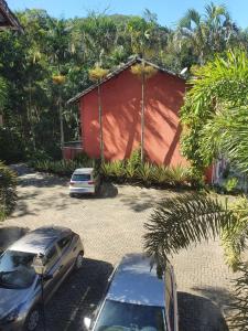 a car parked in a parking lot next to a red building at Cantinho dos Dalto in Itatiaia