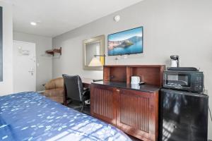 a bedroom with a desk with a microwave and a bed at Travelers Inn Medford I-5 in Medford