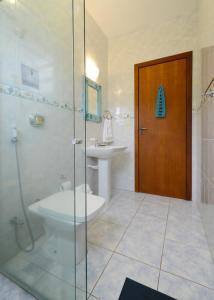 een badkamer met een douche, een toilet en een wastafel bij Casa aconchegante na praia da Daniela in Florianópolis