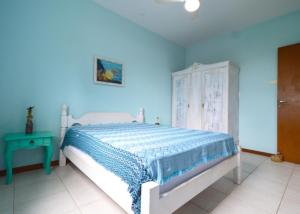 een blauwe slaapkamer met een bed en een blauwe muur bij Casa aconchegante na praia da Daniela in Florianópolis