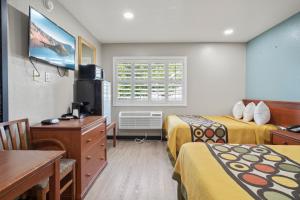 Habitación de hotel con 2 camas y TV en Travelers Inn Medford I-5, en Medford