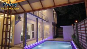 a swimming pool in front of a house at night at Alulu Luxury Residence - Four Bedroom Villa in Cikundul