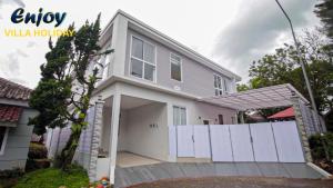 a white house with a white fence at Alulu Luxury Residence - Four Bedroom Villa in Cikundul