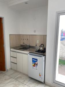 a kitchen with a sink and a refrigerator at Apart Los Algarrobos in Marcos Juárez