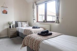 1 dormitorio con 2 camas y ventana en Adrian House, near Hospital, easy parking + garden en Carlisle