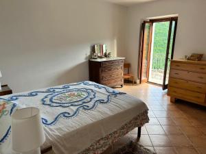 ein Schlafzimmer mit einem Bett, einer Kommode und einem Fenster in der Unterkunft Casa Michela in Caporciano