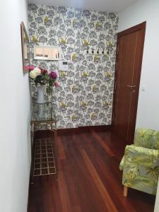 ein Wohnzimmer mit einem Sofa und Blumen an der Wand in der Unterkunft Atrapatuatico in Soto de la Marina