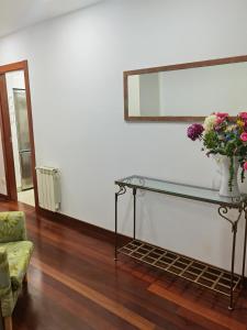 uma sala de estar com uma mesa de vidro com flores em Atrapatuatico em Soto de la Marina