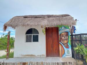 una pequeña casa con una pintura de un hombre en Casa de los Santos Camping y eco cabañas en Holbox Island