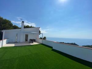 a white house with green grass on the roof at Loft Casa Blanca in Blanes