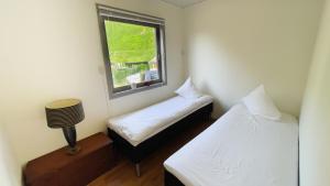 two beds in a small room with a window at Lofoten Red Villa in Laupstad
