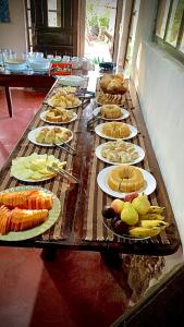 una mesa larga con platos de comida. en Pousada do Sol, en Alto Paraíso de Goiás