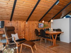 Øster Vrøgumにある4 person holiday home in Oksb lの木製の天井、テーブル、椅子が備わる客室です。
