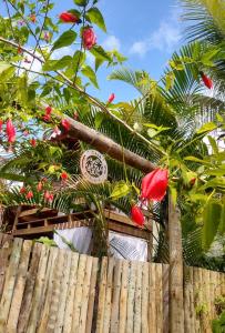 a fence with red flowers on top of it at Casa Marcela in Barra Grande