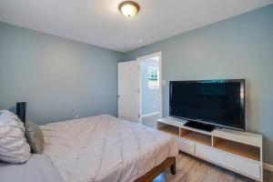 a bedroom with a bed and a flat screen tv at New Cheerful Renovated Home - 5 Min to Downtown! in Savannah