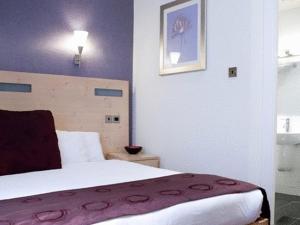 a hotel room with a bed and a lamp at Artto Hotel in Glasgow