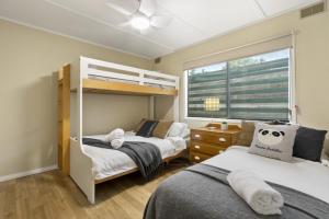a bedroom with two bunk beds and a window at Metung Akora 2Bdrm Apartment 4 Pets and Boats welcome in Metung
